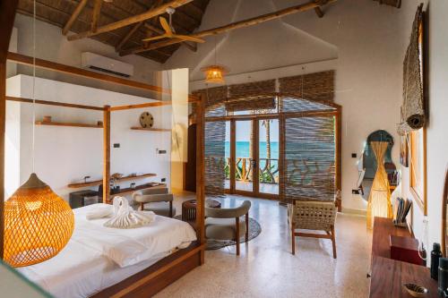 a bedroom with a bed and a table and chairs at Casa Rodi Zanzibar in Jambiani