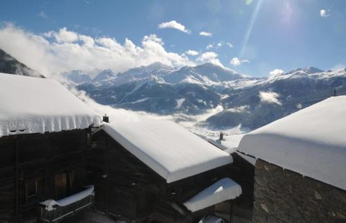 a snow covered roof of a building with snow covered mountains at Laiterie 1 in Verbier