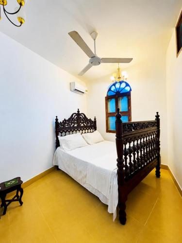 a bedroom with a bed and a ceiling fan at ZANZInest Apartment in Kituoni