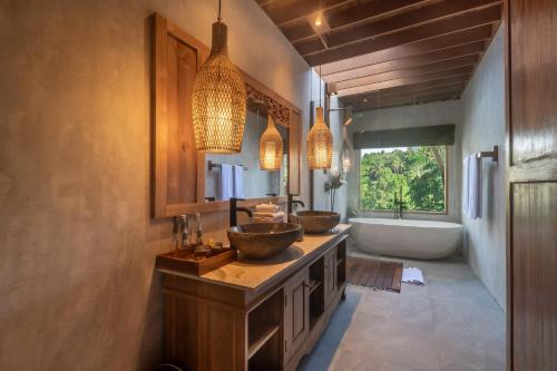 a bathroom with two sinks and a tub and two sinks at The Compass Rose Valley in Ubud
