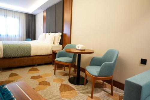 a hotel room with a bed and a table and chairs at Attawfeek Hotel in Tripoli