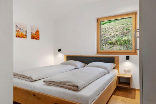 two beds in a room with a window at Oberstarzerhof in Barbiano