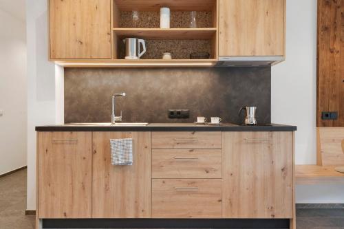 a kitchen with wooden cabinets and a sink at Oberstarzerhof in Barbiano