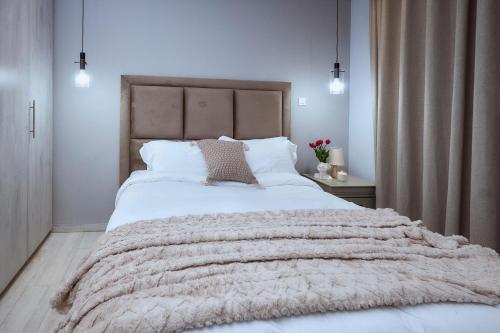 a bedroom with a large bed with a blanket at Pomona Palm Villa in Harare