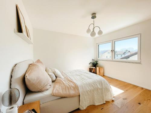 a white bedroom with a couch and a window at 3S Holiday Home in Traunstein