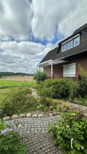 a house with a brick walkway in front of it at Haus Sonnenwest in Rosengarten