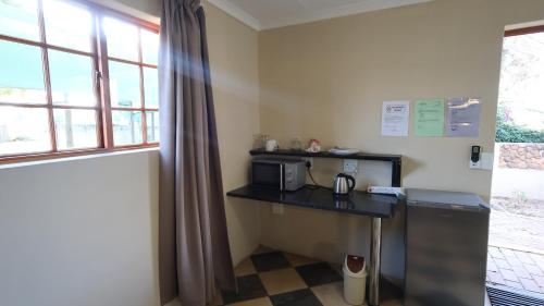 a kitchen with a counter with a microwave and a window at Lanseria Country Estate in Lanseria