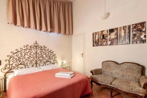 a bedroom with a bed and a chair at Le Civette Country Resort with Pool in Bagno a Ripoli