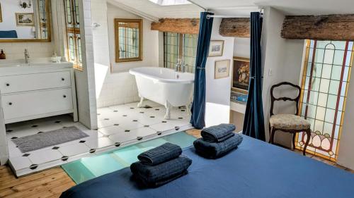 a bathroom with a tub and a sink with two towels at 1860 Bordeaux - Lormont house in Lormont