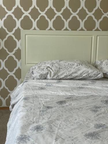 an unmade bed in a bedroom with a wall at Squarehouse Apartment Prishtina in Prishtinë