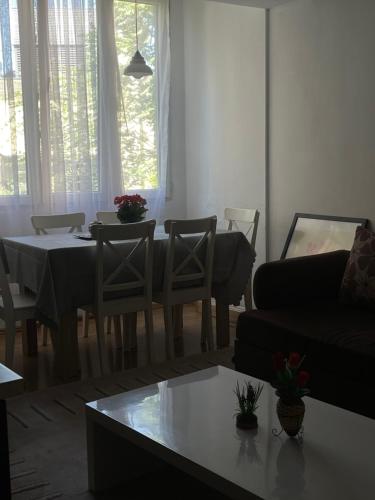 a living room with a table and chairs and a couch at Squarehouse Apartment Prishtina in Prishtinë