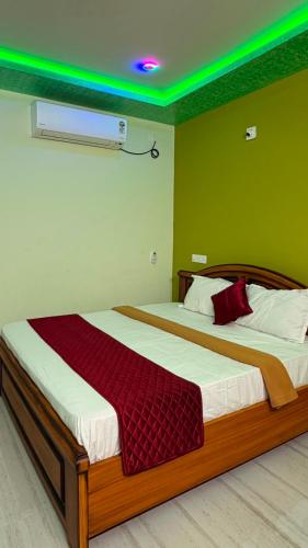 two beds in a room with a green wall at pnrpalace in Bāpatla
