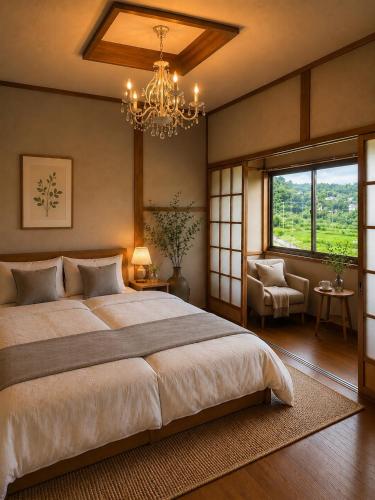 a bedroom with a large bed and a chandelier at 貸切り200m2 林檎のワルツ 広い和モダン邸宅 星空とBBQ in Komoro
