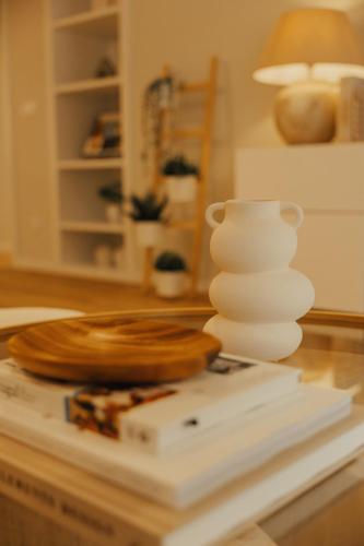 a white vase sitting on top of a book at Gerês Thermae Retreat in Geres