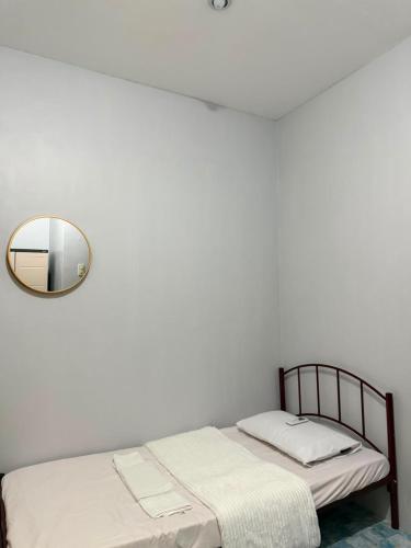 a white bedroom with a bed and a mirror at Amori Spaces - MRG in Maribago
