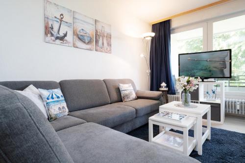 a living room with a couch and a tv at Waldstraße 2 Ferienwohnung Volkenborn in Kellenhusen