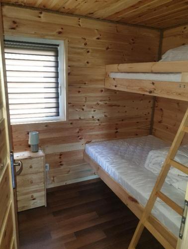 a bedroom with a bunk bed in a log cabin at Domki u Grega na kaszubach in Wiele