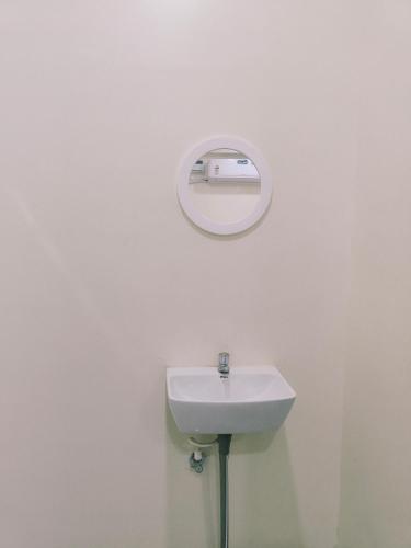 a white bathroom with a sink and a mirror at Bheemas Grand Ps9 in Srikalahasti