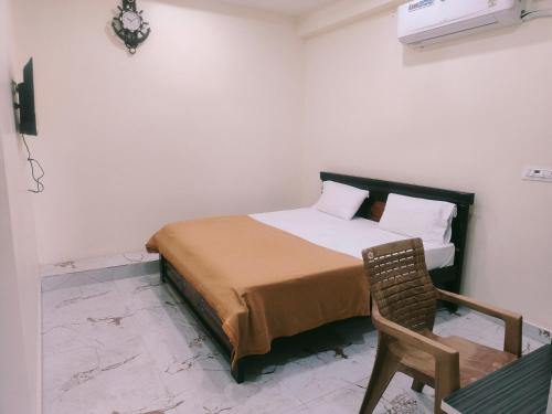a bedroom with a bed and a chair in it at Bheemas Grand Ps9 in Srikalahasti
