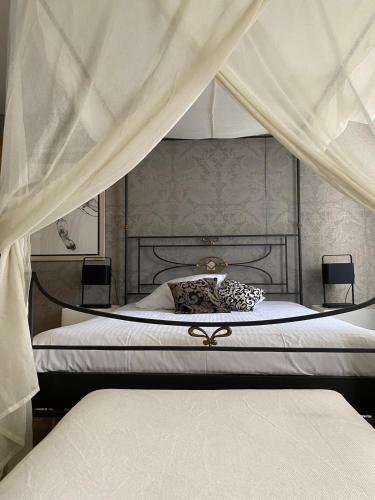 a bedroom with two beds and a canopy with curtains at B&B Villa Des Raisins in Bruges