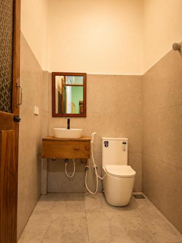 a bathroom with a toilet and a sink at Eagle Resort Arugambay in Arugam Bay
