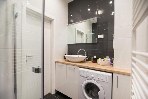 a bathroom with a washing machine and a sink at Apartment Center Four stars in Zagreb