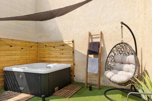 a hot tub in a yard with a swing at La Parenthèse du Loir in Château-du-Loir