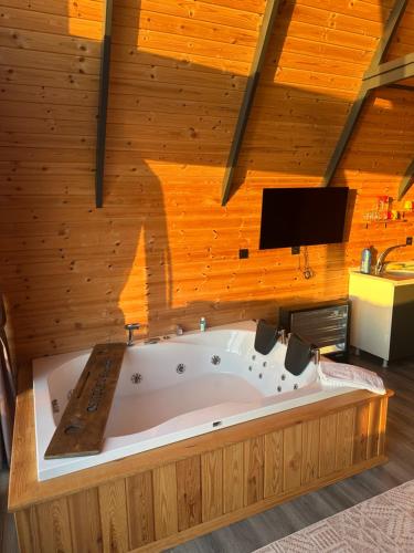 a large bath tub in a room with wooden walls at Deniz Üstü Bungalov in Fındıklı