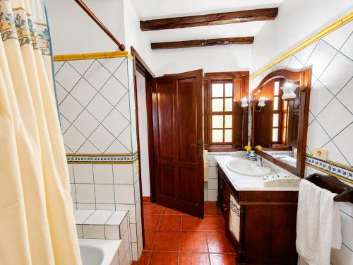 a bathroom with a tub and a sink and a mirror at Tomasín in Puntallana