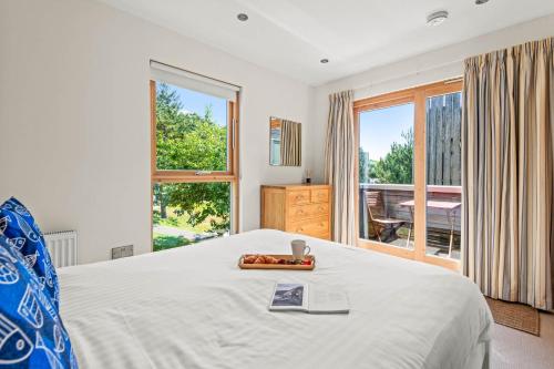 a bedroom with a bed and a large window at House 6 in Looe