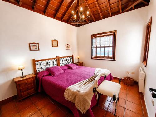 a bedroom with a bed with a purple bedspread at Tomasín in Puntallana