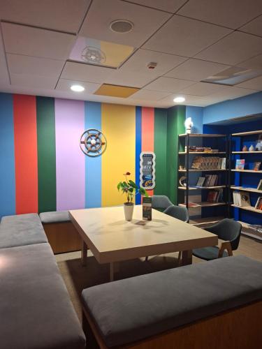 a room with a table and chairs and a colorful wall at Hostel Gdańsk Szafarnia 10 Old Town in Gdańsk