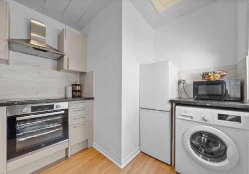 a kitchen with a washing machine and a washer at Albion Apartment by Klass Living Coatbridge in Coatbridge
