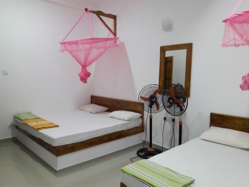 a room with two beds and a mirror at All View Safari Cottage in Timbulketiya