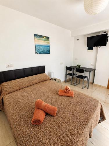 a bedroom with a bed with two towels on it at Los Barqueros Suites Palm in Corralejo