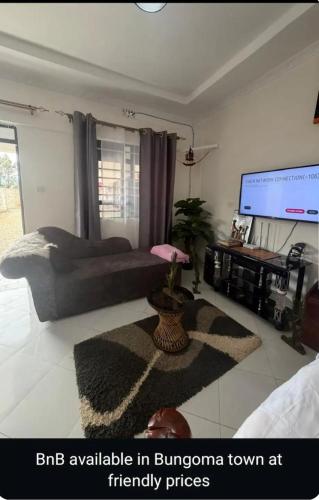 a bedroom with a bed and a flat screen tv at NewNest in Bungoma