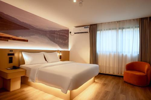 a bedroom with a large white bed and a chair at Ivy Hotel Lagos Ikeja in Hausa