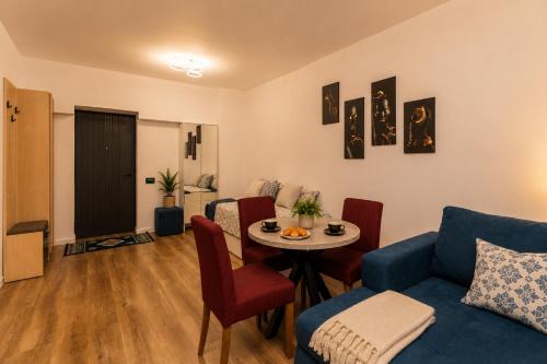 ein Wohnzimmer mit einem blauen Sofa und einem Tisch in der Unterkunft Wise Nest Studio with pool and spa in Sinaia
