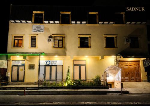 a building with doors and windows at night at Family Guest House SadNur in Bukhara