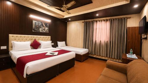 a hotel room with two beds and a couch at Hotel Red Hut Chandigarh railway station in Zirakpur