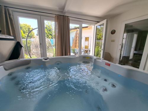 a large blue tub in a room with windows at Kúria Apartman Extra in Budapest