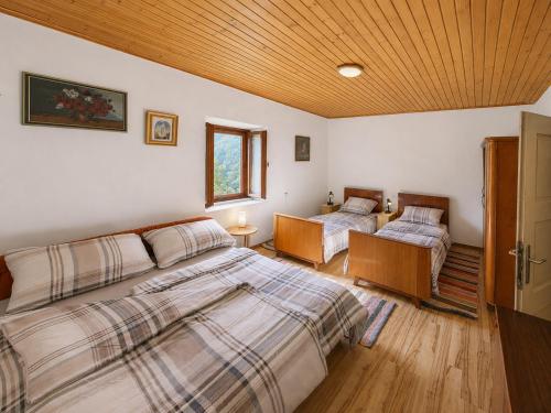 a bedroom with two beds and a wooden ceiling at Kuca za odmor Lipa in Sinac