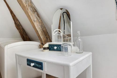 a white dressing table with a mirror on it at Logis des gourmets in Hommes