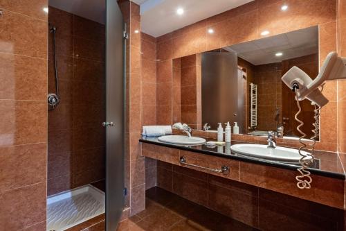 a bathroom with two sinks and a shower at Suites Del Borgo in Olbia