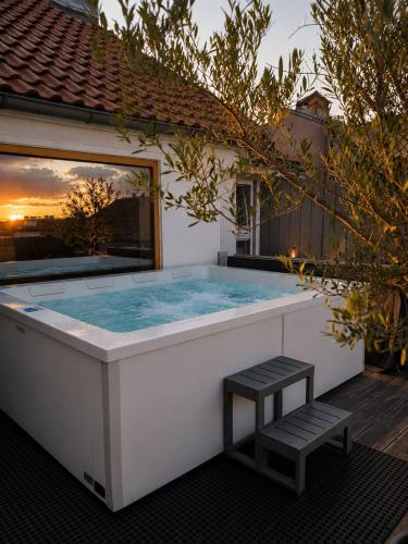 a hot tub with a bench in front of a house at Hotel Residenz in Ravensburg