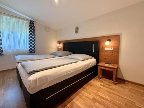 a bedroom with a large bed with a wooden headboard at Hotel Heimfeld Restaurant Cafe in Garching an der Alz