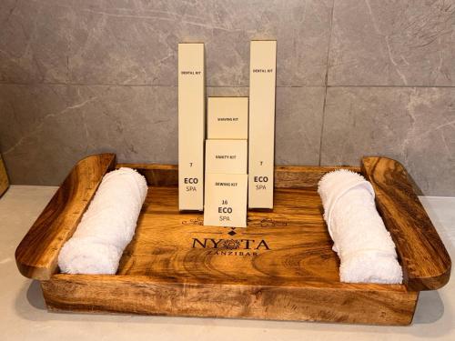 a wooden tray with two towels on top of it at Nyota Boutique Hotel Zanzibar in Nungwi