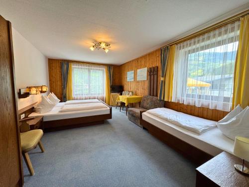 a hotel room with two beds and a window at Sporthotel Flachauwinkl in Flachau