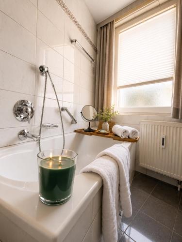 a bathroom with a candle on a bath tub at Hotel Kreuzplatz Gießen Zentrum in Gießen