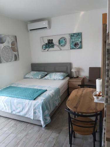 a bedroom with a bed and a wooden table at Apartments Peričić in Podstrana